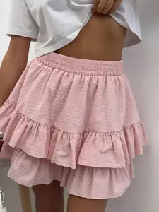 Close-up detail of pink high-waisted ruffled mini skirt with textured Swiss dot fabric