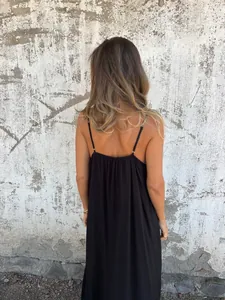 Elegant back view detail of a long black spaghetti strap dress with a flowing silhouette