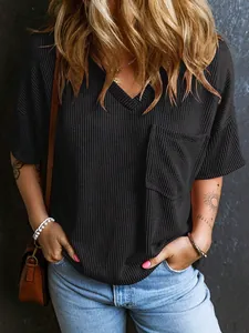 Dettaglio maglia nera da donna con scollo a V, trama a nido d'ape e taschino frontale corto