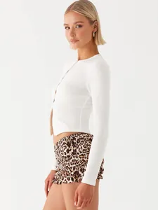 Side profile of a slim fit white ribbed cropped cardigan with button front closure