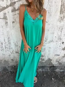 Detailed view of the vibrant green lace-trimmed neckline on this spaghetti strap maxi dress.
