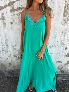 Close-up detail of a vibrant green long slip dress featuring elegant lace V-neck trim