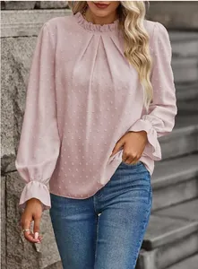 Dettaglio di un'elegante camicetta rosa chiaro a pois con collo a volant e pieghe