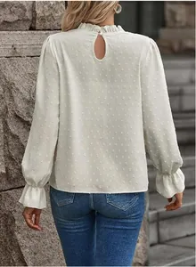 Elegante vista posteriore della camicetta a maniche lunghe color crema con pois chic.