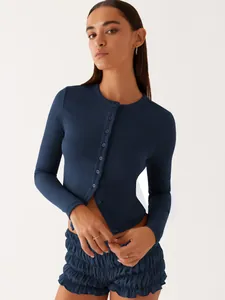 Detailed close-up of a model wearing a navy blue slim-fit ribbed long-sleeve cardigan top