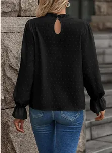 Vista posteriore di un top nero in jacquard a maniche lunghe con polsini a volant