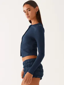 Side view of navy blue ribbed slim-fit cropped button-up cardigan with long sleeves