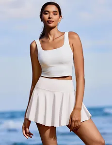 Outdoor lifestyle foto van een vrouw in een witte geplooide tennisrok en sporttop
