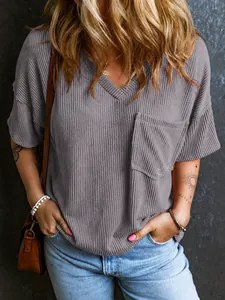 Detailed view of the textured waffle knit fabric and chest pocket on this stylish V-neck top