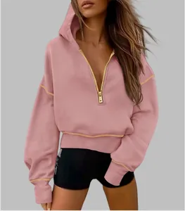 Close-up detail of women's pink half-zipper cropped hoodie with stylish gold zipper