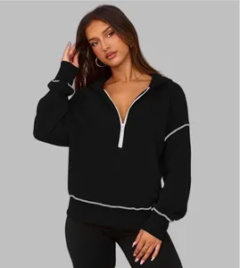 Detail view of stylish women's black half-zip cropped hoodie with contrast stitching