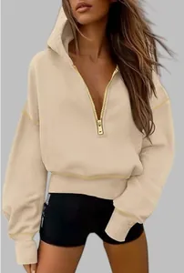 Detailed view of women's half-zip beige cropped hoodie with gold zipper and hood