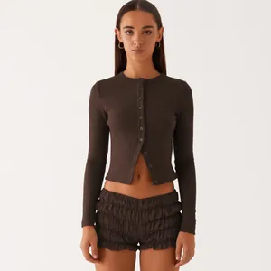 Front view of slim-fit brown ribbed button-up cropped cardigan and ruffled shorts