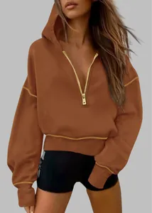 Detail view of stylish women's half-zip cropped brown hoodie with gold zipper hardware