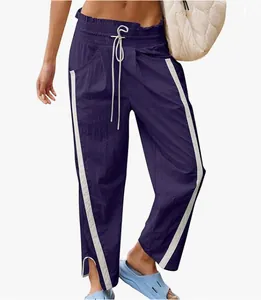 Detailed view of women's Y2K high-waisted purple sports pants with white side stripes