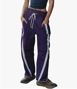 Detail view of purple Y2K sports pants featuring white side stripes and drawstring