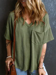 Dettaglio di un top da donna a maniche corte in maglia a nido d'ape verde con scollo a V