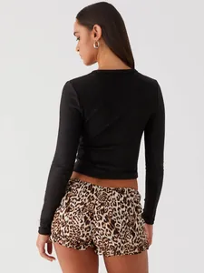 Back view of black slim fit ribbed long sleeve crop top paired with leopard shorts