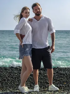 Couple portant des chemises de plage à capuche en coton et lin sur une plage