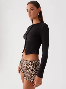 Side view of a slim fit black ribbed long sleeve cropped cardigan button-up top