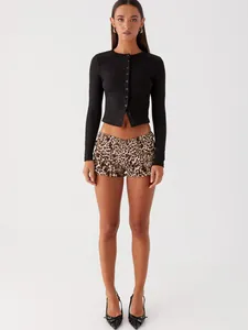 Full body view of a black slim-fit button-up crop cardigan and leopard shorts.
