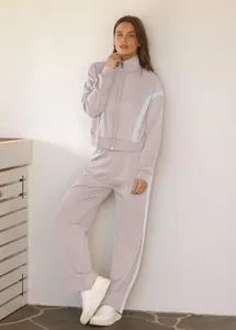 Lässiger lila Trainingsanzug für Damen mit blauen Seitenstreifen und Reißverschlussjacke.
