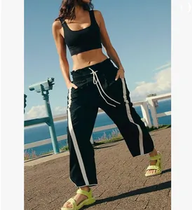 Stylish women's black high-waisted wide-leg sweatpants featuring white side stripes and drawstring