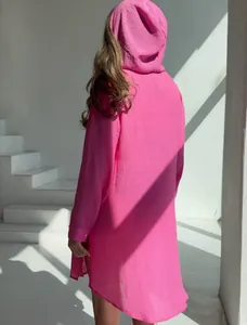 Vue arrière d'une chemise de plage à capuche rose vif pour femmes en vacances au soleil
