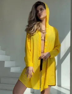 Vue détaillée d'un cardigan de plage jaune à capuche avec texture froissée.