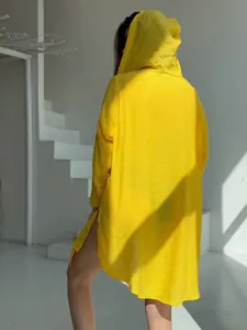 Vue arrière d'une longue chemise de protection solaire jaune à capuche avec fentes latérales