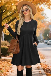 Close-up of black ribbed long-sleeve dress with warm autumn street background