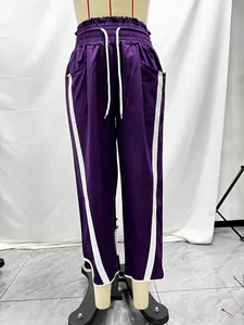 Detail view of purple Y2K sports pants with white side stripes and high waist drawstring
