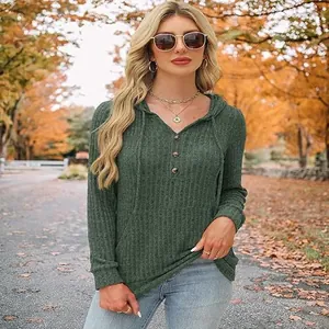 Vue de face d'un sweat à capuche côtelé vert pour femme dans un décor d'automne.