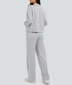 Vista posterior detallada del chándal gris claro de dos piezas para mujer con rayas blancas