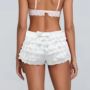 Detaillierte Rückansicht der weißen, gestuften Mini-Spitzenshorts mit eleganter Schleife
