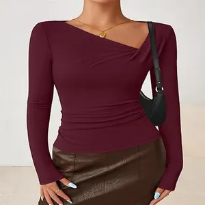 Detailed view of women's wine red slim-fit top with unique irregular neckline