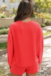 Vue arrière d'un ensemble rouge côtelé pour femme avec haut à manches longues et short.
