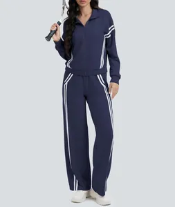 Detalle de chándal azul marino de dos piezas con rayas blancas y pantalones de pierna ancha