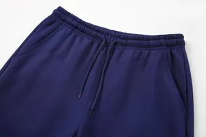Close-up of navy blue sports pants showing drawstring waist and mesh fabric texture.