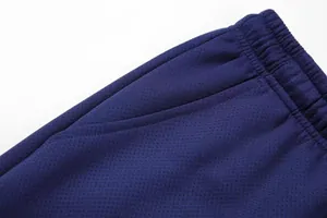 Close-up of navy blue athletic sweatpants showing elastic waistband and pocket detail.