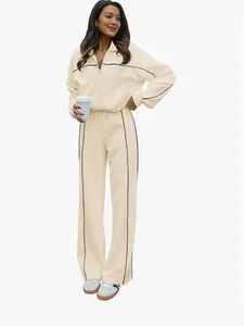 Ensemble de survêtement beige deux pièces pour femme avec rayures noires et zippé