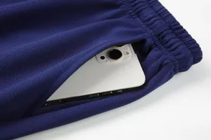 Detailed close-up showing the deep side pocket capacity on navy blue athletic sweatpants