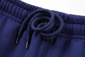 Close-up detail of navy blue athletic pants featuring a drawstring elastic waistband
