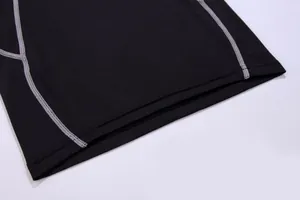 Detailed macro shot of grey flatlock stitching on professional black compression wear
