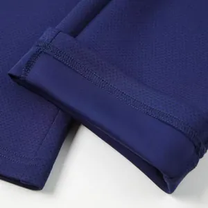 Close-up of navy blue athletic sweatpants cuff showing mesh fabric texture