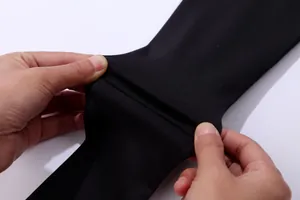 Close-up of black high-elasticity quick-dry sports fabric being stretched by hands