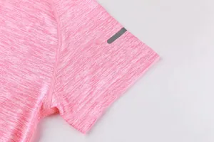 Detail of pink quick-dry sports t-shirt sleeve with reflective stripe and flat seams.