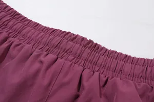 High-quality close-up of the elastic waistband and stitching on women's purple yoga pants