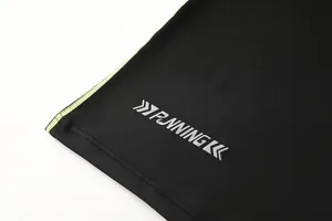 Dettaglio ravvicinato del logo RUNNING riflettente e cuciture neon sulla maglia sport