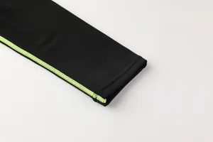 Dettaglio cuciture piatte verde neon su manica di maglia a compressione per bambini